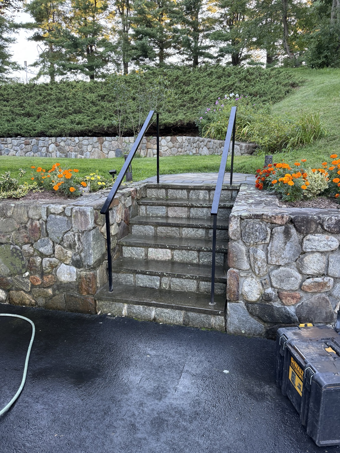 Minimal black exterior handrails installed on stone stairs
